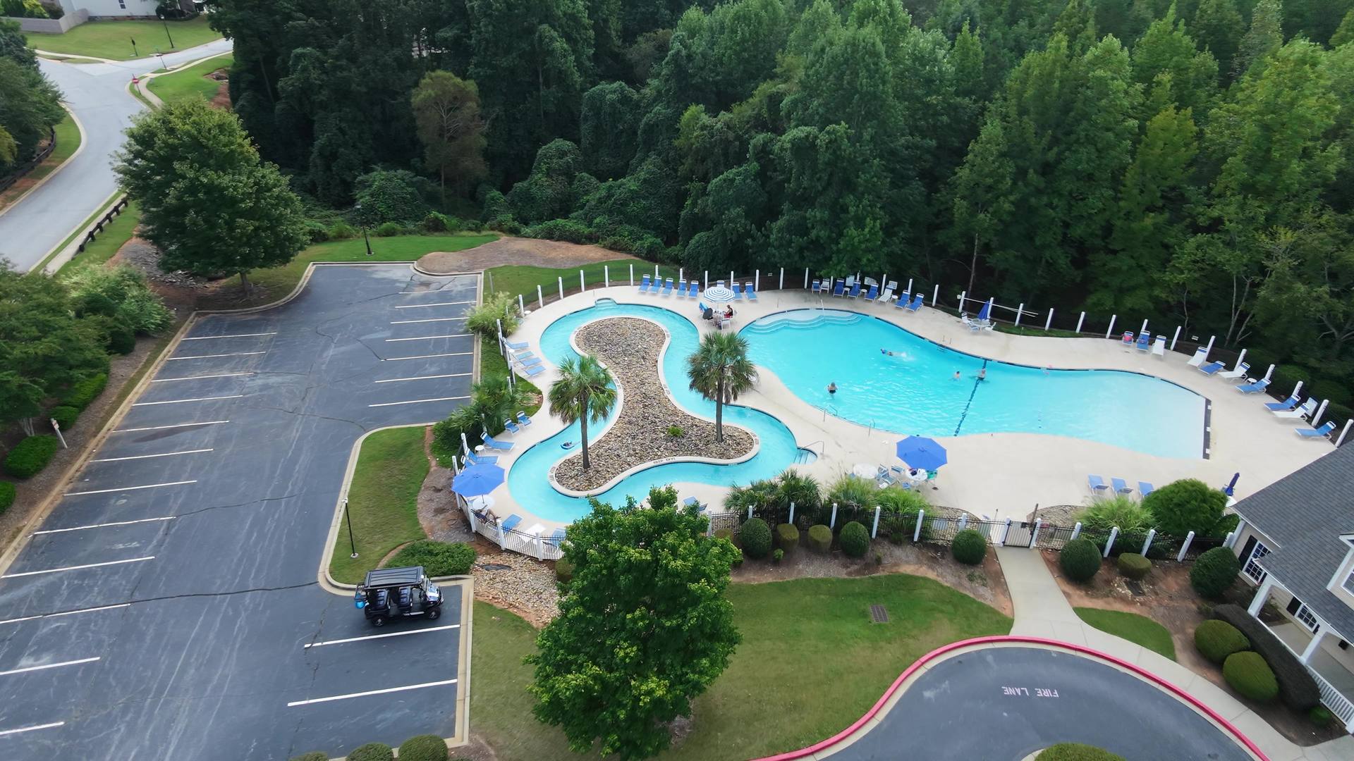 Aerial view of the pool and lazy river, with two palms on the island
