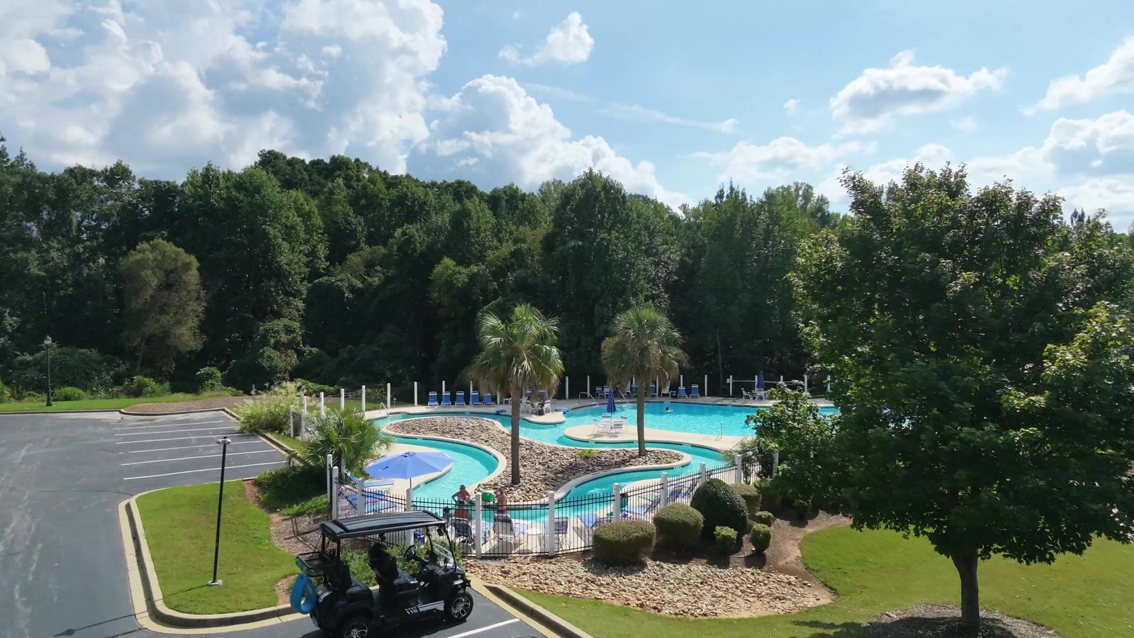 The pool, lazy river and palms on a summer afternoon